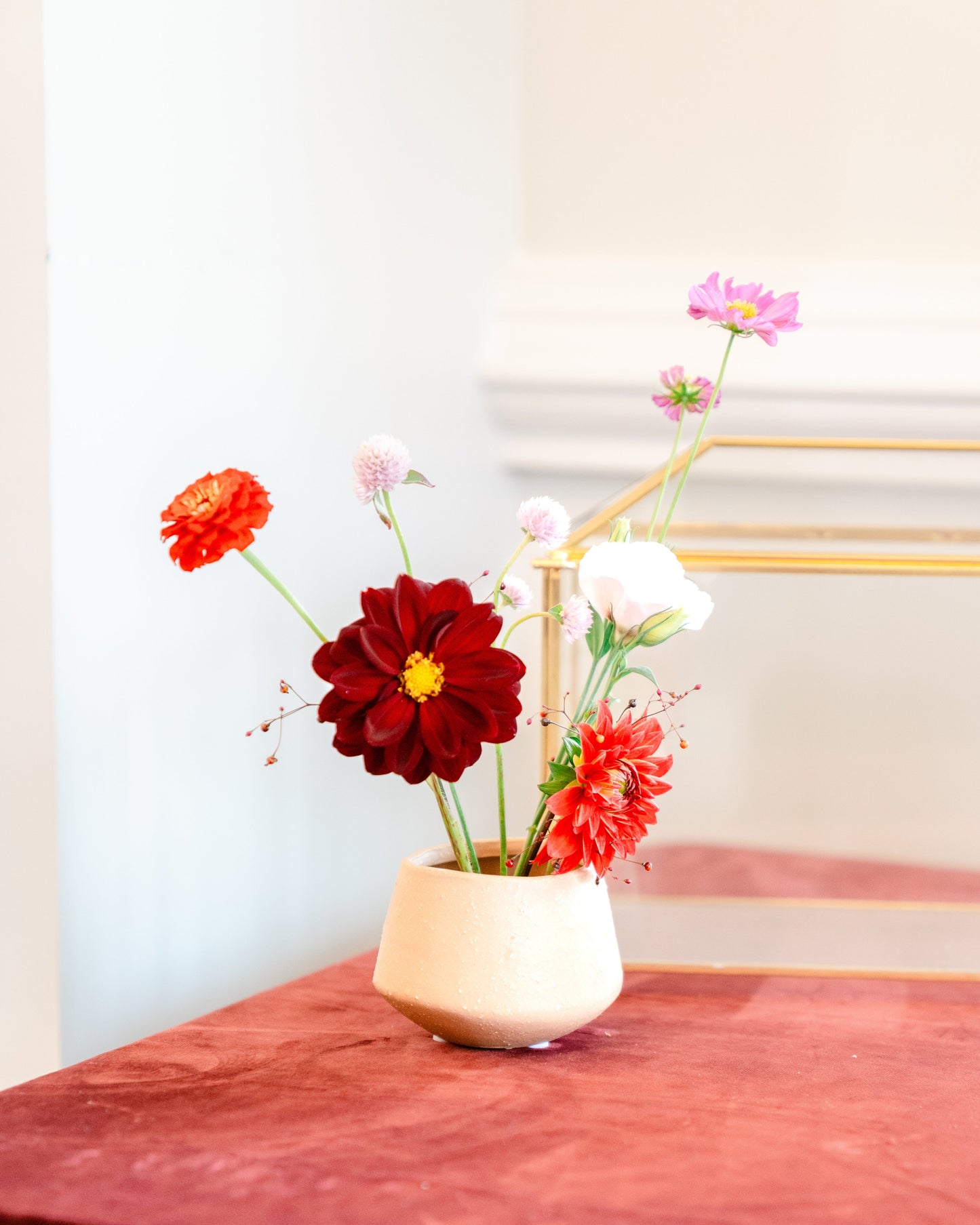 Small vase with red and white flowers on a red tablecloth