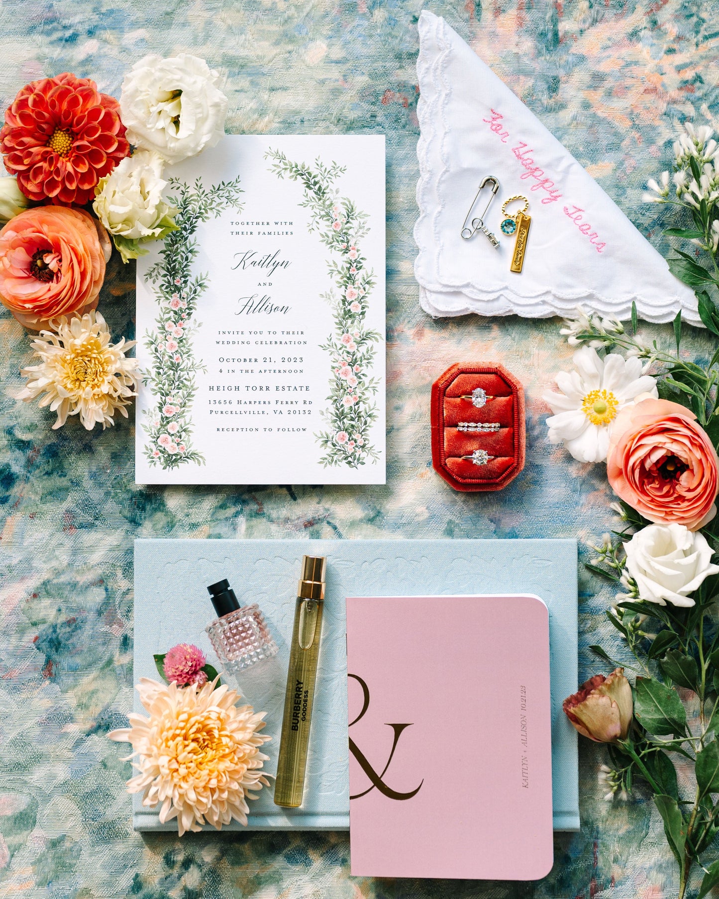 Wedding invitation set with flowers and jewelry on a textured surface
