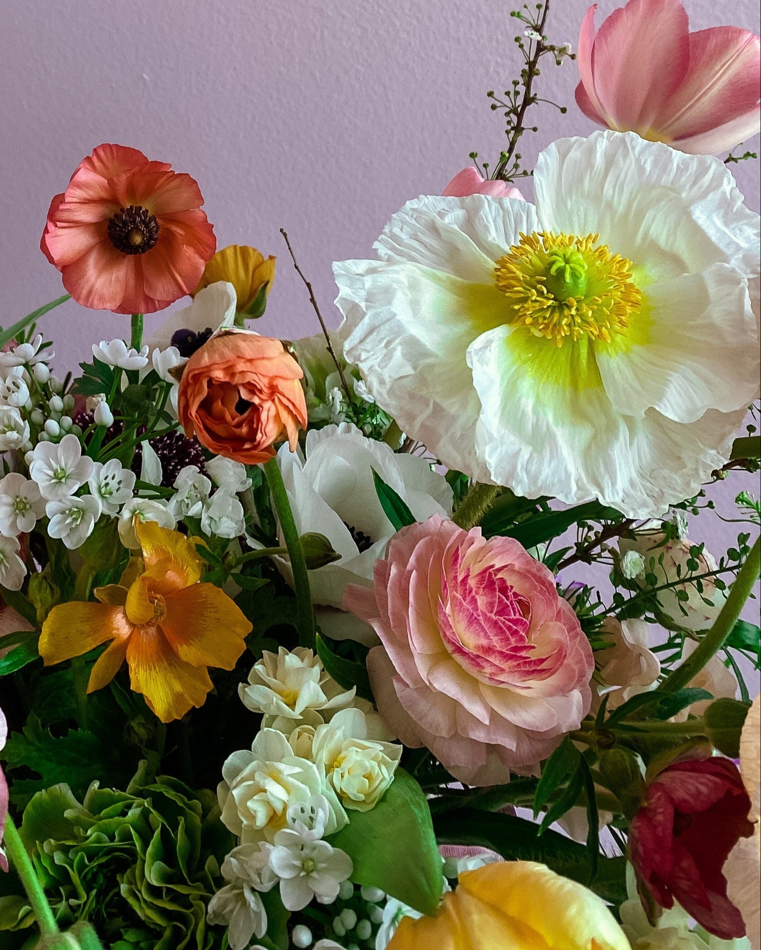 Colorful bouquet of flowers against a light purple background