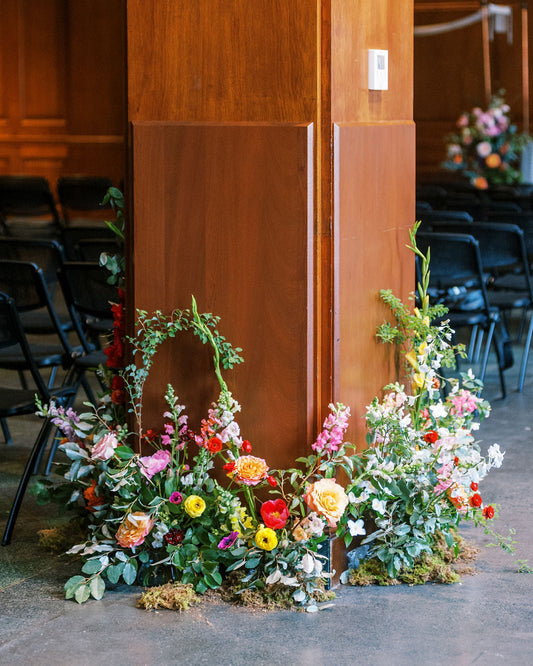 Floral arrangement against a wooden wall in an indoor setting