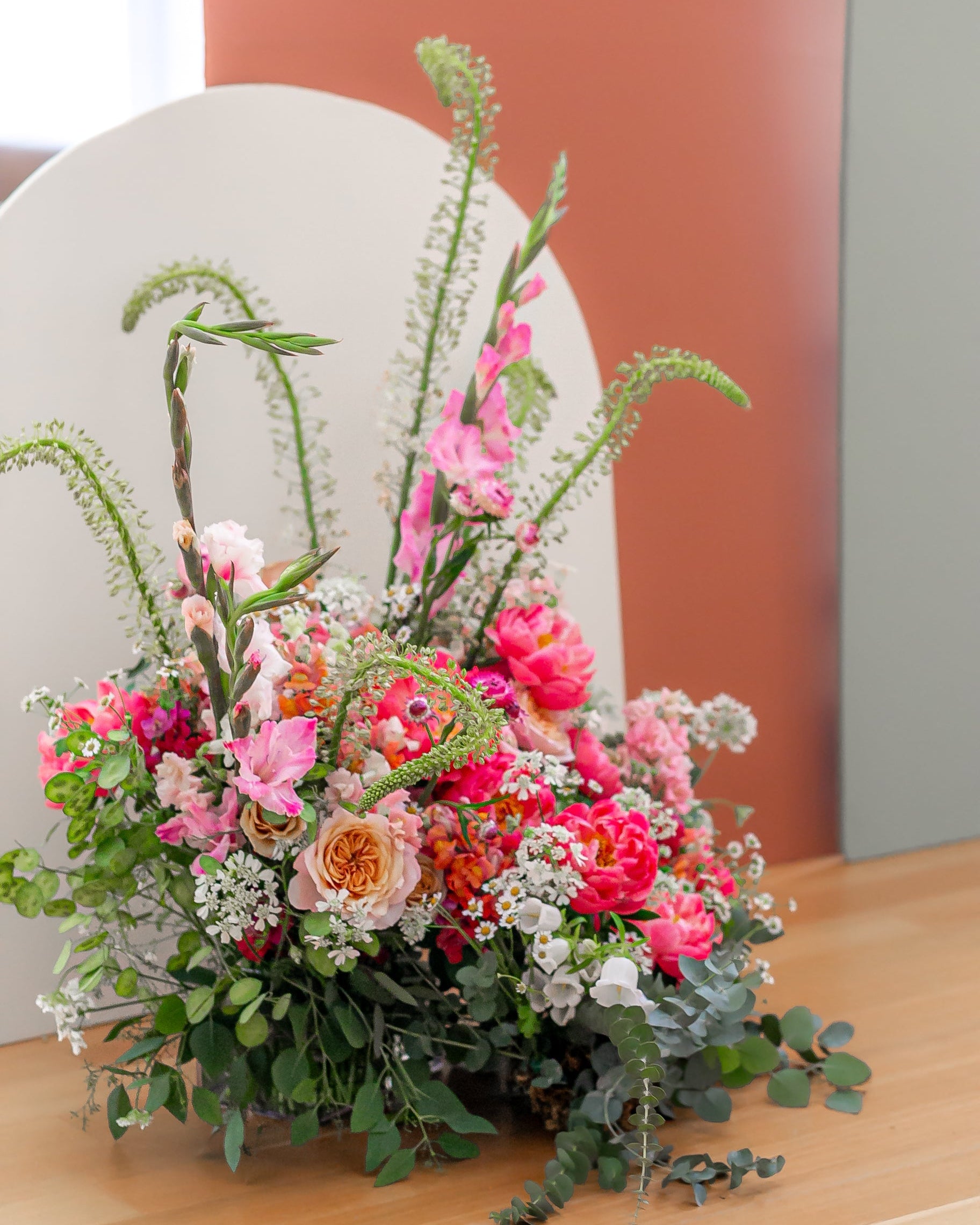 Colorful floral arrangement on a wooden surface with a blurred background